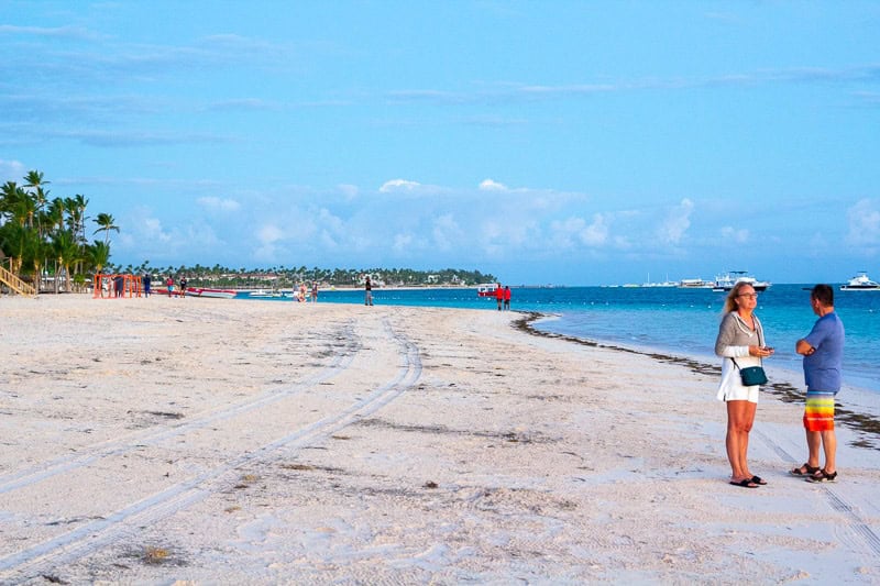 Quiet Caribbean beach with palm trees and soft sand, ideal for family vacations and honeymoon trips, featuring clear blue waters and sunny skies.