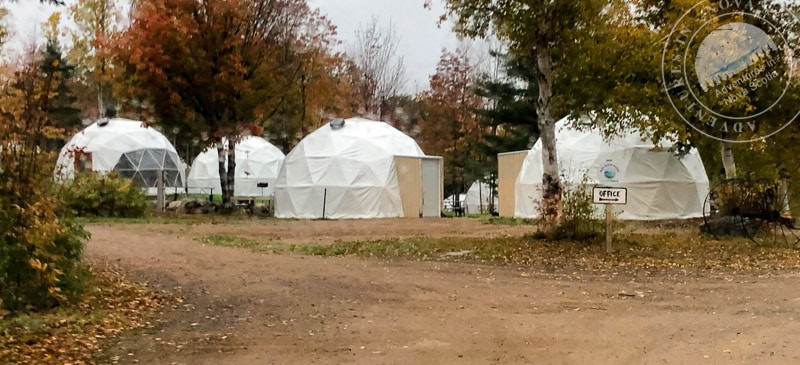 Yurt-style accommodations at Atlantic Destinations with scenic fall foliage and outdoor setting, offering unique glamping experiences in nature.