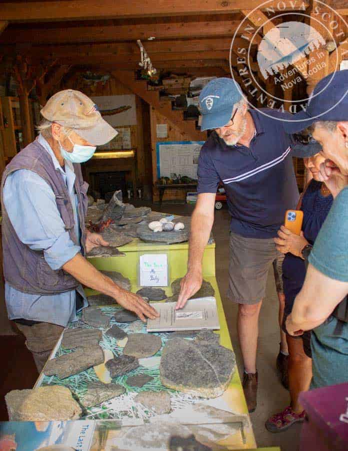 Rock collecting demonstration at Atlantic Destinations museum with visitors learning about local geology in Nova Scotia, highlighting eco-tours and educational travel experiences in Atlantic Canada.
