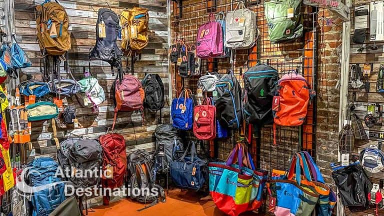 Durable outdoor backpacks and travel gear display in a retail store, perfect for adventure trips and vacations. Wide variety of colorful backpacks, suitable for travel, hiking, and outdoor activities.