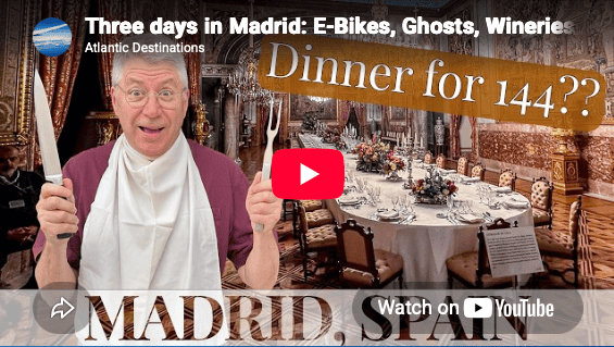 Image of author in front of the Madrid Palace dining room with place settings for 144 people. Guided tours like these are fun and educational for travel over 50.